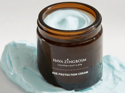 קרם AGE PROTECTION של חוה זינגבוים במרקם כחול-בהיר בצנצנת זכוכית חומה.